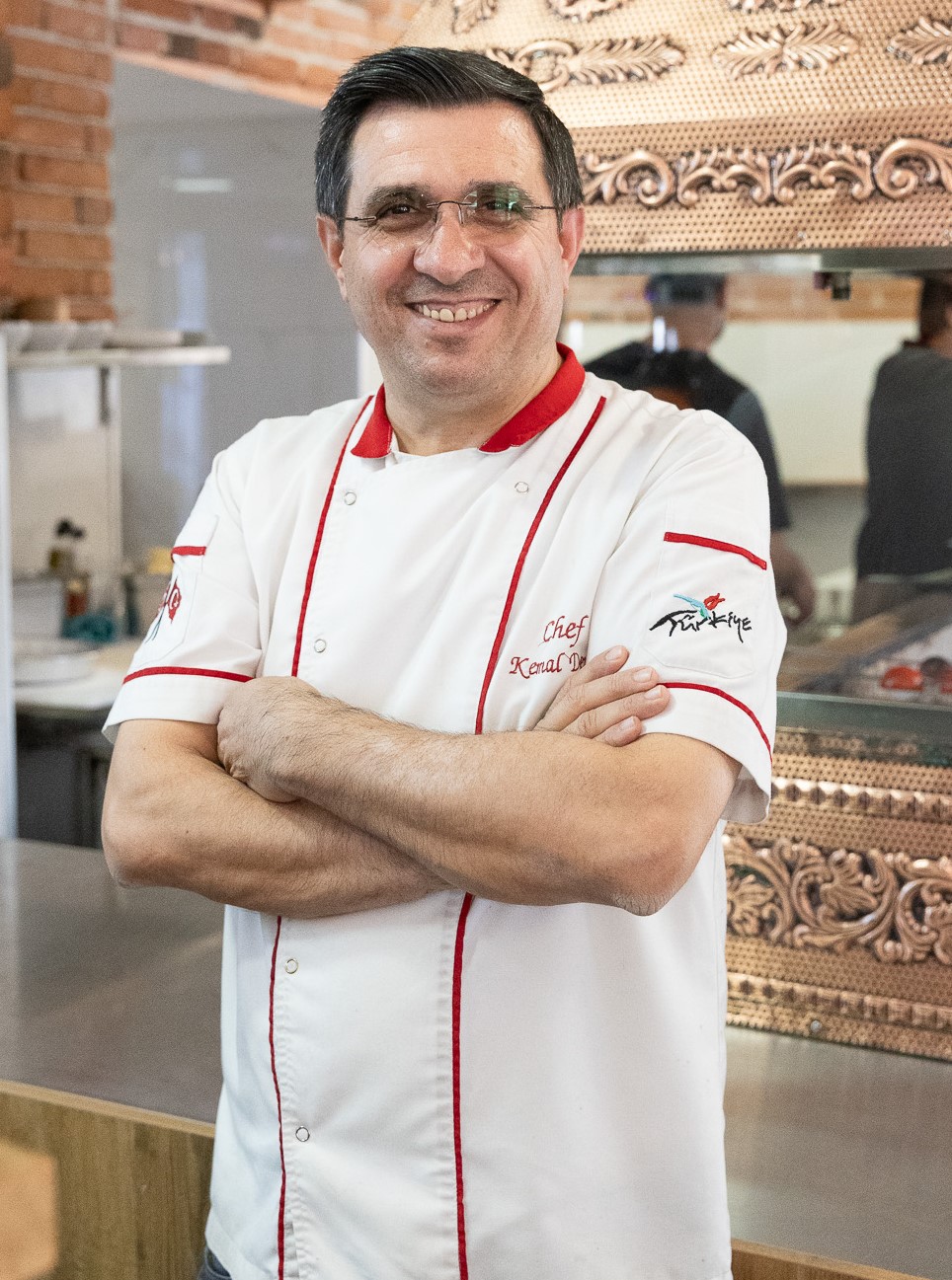 Šef Kemal Deniz standing in front of his famous grill set.